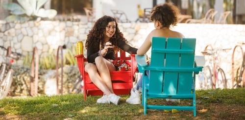 two students sit in Adirondack chairs on the mounds